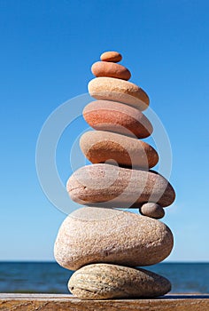 Rock zen pyramid of colorful pebbles on a background of blue sky