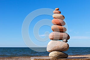 Rock zen pyramid of colorful pebbles on a background of blue sky