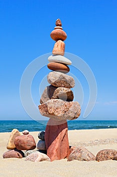 Rock zen pyramid of colorful pebbles on the background of the sea. Concept of balance, harmony and meditation