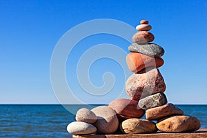 Rock zen pyramid of colorful pebbles on the background of the sea. Concept of Life balance