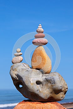 Rock zen pyramid of stones of different shapes on a background of blue sky and sea