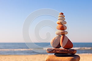 Rock zen pyramid of white and pink pebbles on a background of bl