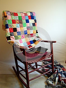 Rocker, antique quilt. Reading book. 