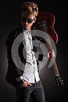 Rocker holding his guitar on shoulder and looking back