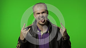 Rocker man showing rock and roll sign, devil horns gesture, looking with crazy expression