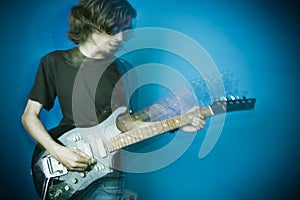 Rocker playing guitar on blue