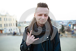 Rocker rock star young man walking on the city street autumn day