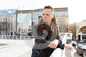 Rocker rock star young man walking on the city street autumn day