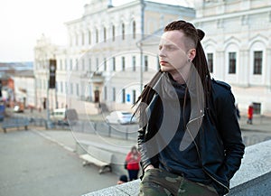 Rocker rock star young man walking on the city street autumn day