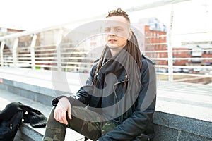 Rocker rock star young man walking on the city street autumn day