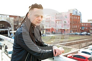 Rocker rock star young man walking on the city street autumn day