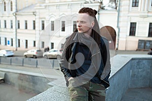 Rocker rock star young man walking on the city street autumn day