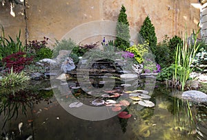 Rockery with different flowers and shrubs on a lake with goldfish.