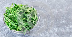 Rocket salad or arugula leaves in glass bowl, horizontal, copy space
