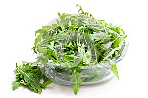 Rocket salad leaves in glass bowl isolated on white