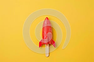 Rocket shaped summer ice lolly on a bright yellow background