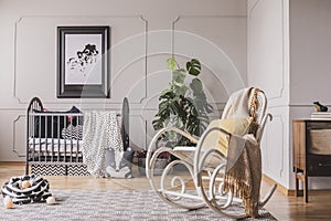 Rocking chair with blanket and pillow in stylish baby room