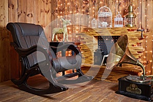 Rocking-chair and gramophone near fireplace in