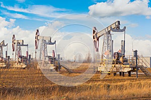 Rocking chair of an oil rig pump in the autumn on an oil field in Russia