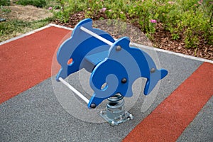 Rocking children in the form of a Dolphin on the Playground with rubberized surface.