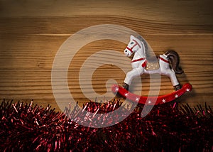 Rocking Horse Toy over wooden texture background with glossy garland