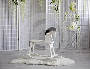 Rocking toy horse in the white room with white wall