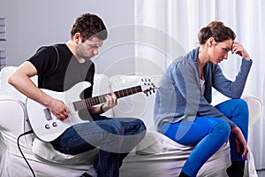 Rockman playing guitar and bored woman