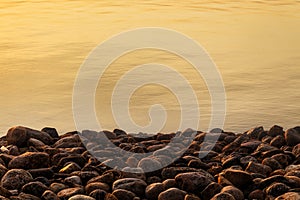 Rocks along a waterline at sunset