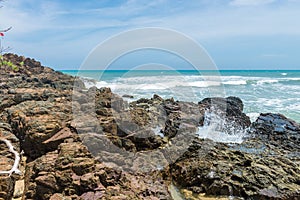 Rocks by the beach with waves splahes