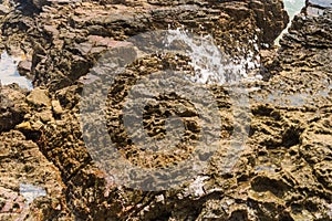 Rocks by the beach with waves splahes