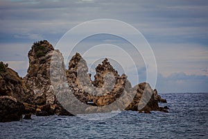 Rocks of bizarre shapes in Paleokastritsa bay on a rainy day