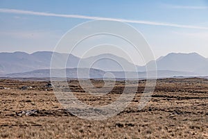 Rocks in a bog with Twelve Bens mountains in background