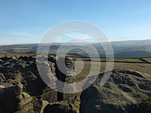 Rocks and boulders on bridestones moor in west yorkshire in sunlight and shadow