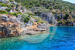 Rocks and bright turquoise water in the Mediterranean Sea. Ruins of an ancient city in Bodrum photo