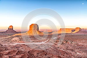 Rocks and buttes of Monument Valley at sunset with full moon