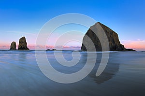 the rocks of cannon beach are shown at sunset on this beautiful day