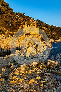 Rocks and cliffs shoreline of Cap Ferrat cape hosting Saint-Jean-Cap-Ferrat resort town on at French Riviera in France