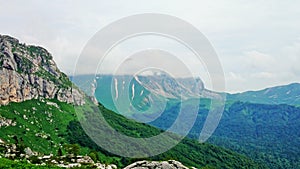 Rocks in clouds and green valleys below