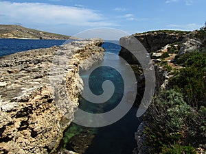 Rocks of the coastline of Comino in Malta surrounded by water