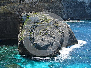 Rocks of the coastline of Comino in Malta surrounded by water