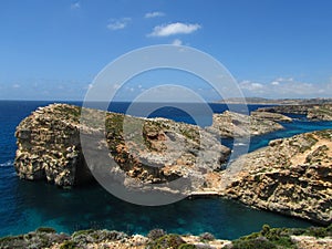 Rocks of the coastline of Comino in Malta surrounded by water