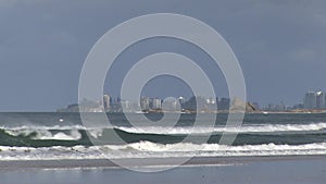 The rocks of Currumbin headland, with Coolangatta behind, visible from Palm Beach, Gold Coast, Australia.