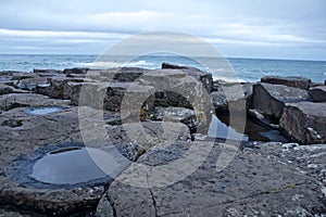 Rocks of Giants Causeway with Puddles on some rocks and Ocean behind