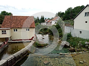 Rocks, houses and Duman, the spring of the Bistrica River in the small town of Livno in Bosnia and Herzegovina