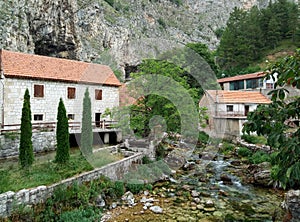 Rocks, houses and Duman, the spring of the Bistrica River in the small town of Livno in Bosnia and Herzegovina