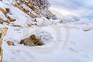 Rocks in Lake Baikal covered with ice and snow