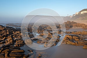 Rocks in the mist at Morgan Bay beach at sunset, Wild Coast, Eastern Cape, South Africa.