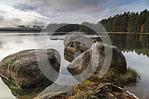 Rocks and moody sky on Loch Garten in Scotland.