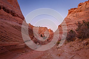 Rocks and Mountains along a trail to Tunnel Slot during sunny day with blue sky in Escalante National Monument