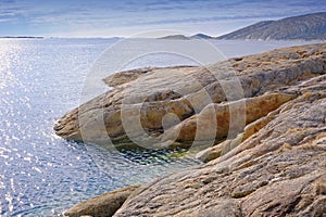 Rocks, nature and ocean by beach with blue sky, waves and coastline for outdoor travel destination. Seascape, water and